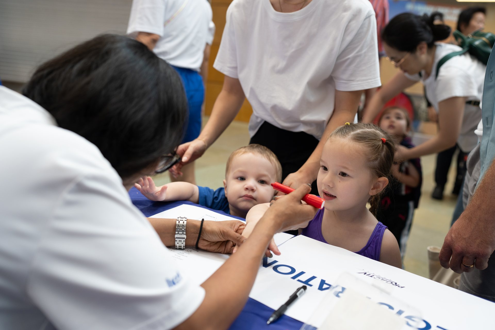 Families registering at the welcome desk of a ProActiv Sports event