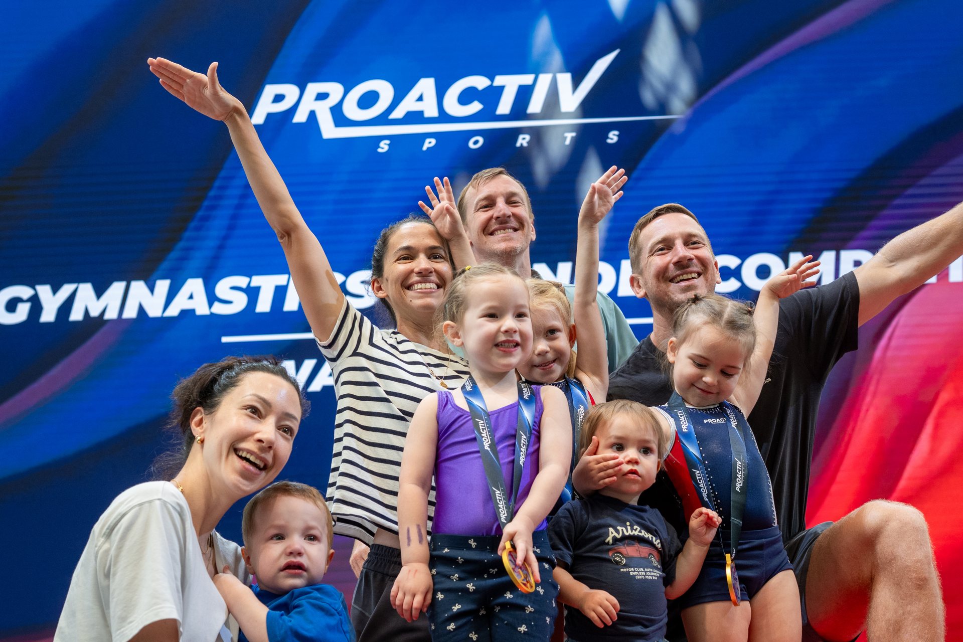 Families celebrating with their medals at a ProActiv Sports gymnastics event