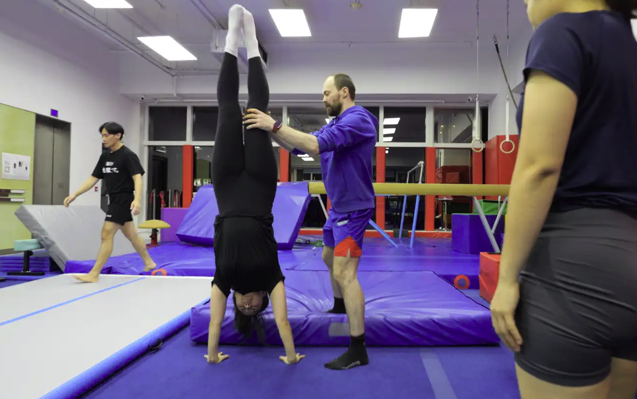 Adult class handstand training on mats