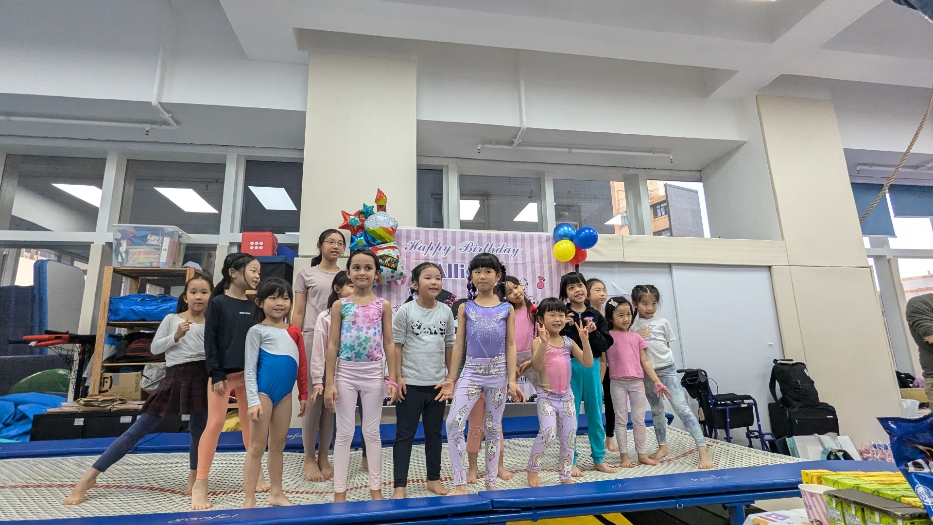Birthday group photo in front of the Happy Birthday backdrop at ProGym Hong Kong