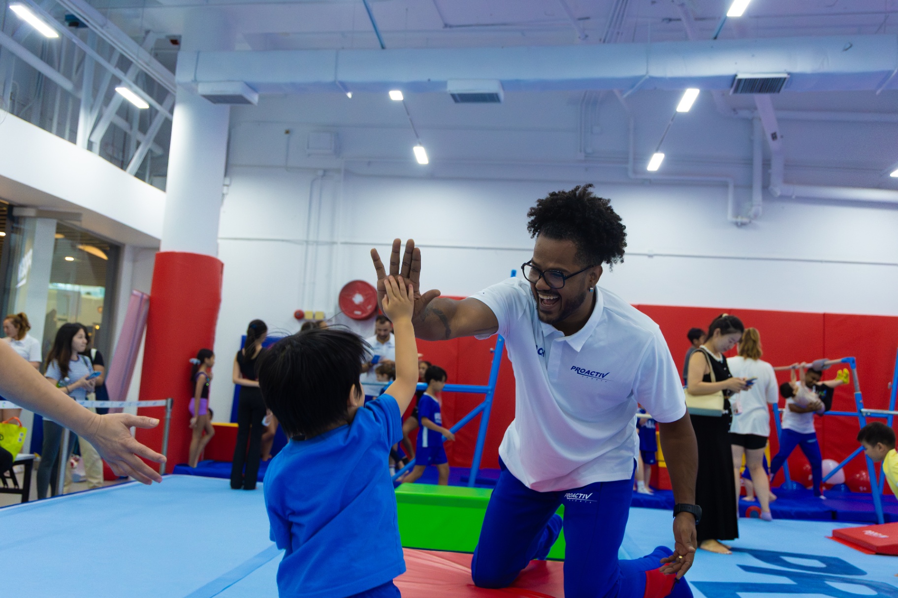 Coach high-fiving young gymnast at ProGym