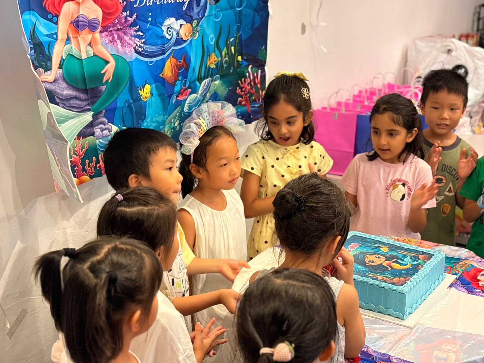 Children gathered around a mermaid-themed birthday cake at Prodigy at Katong Point