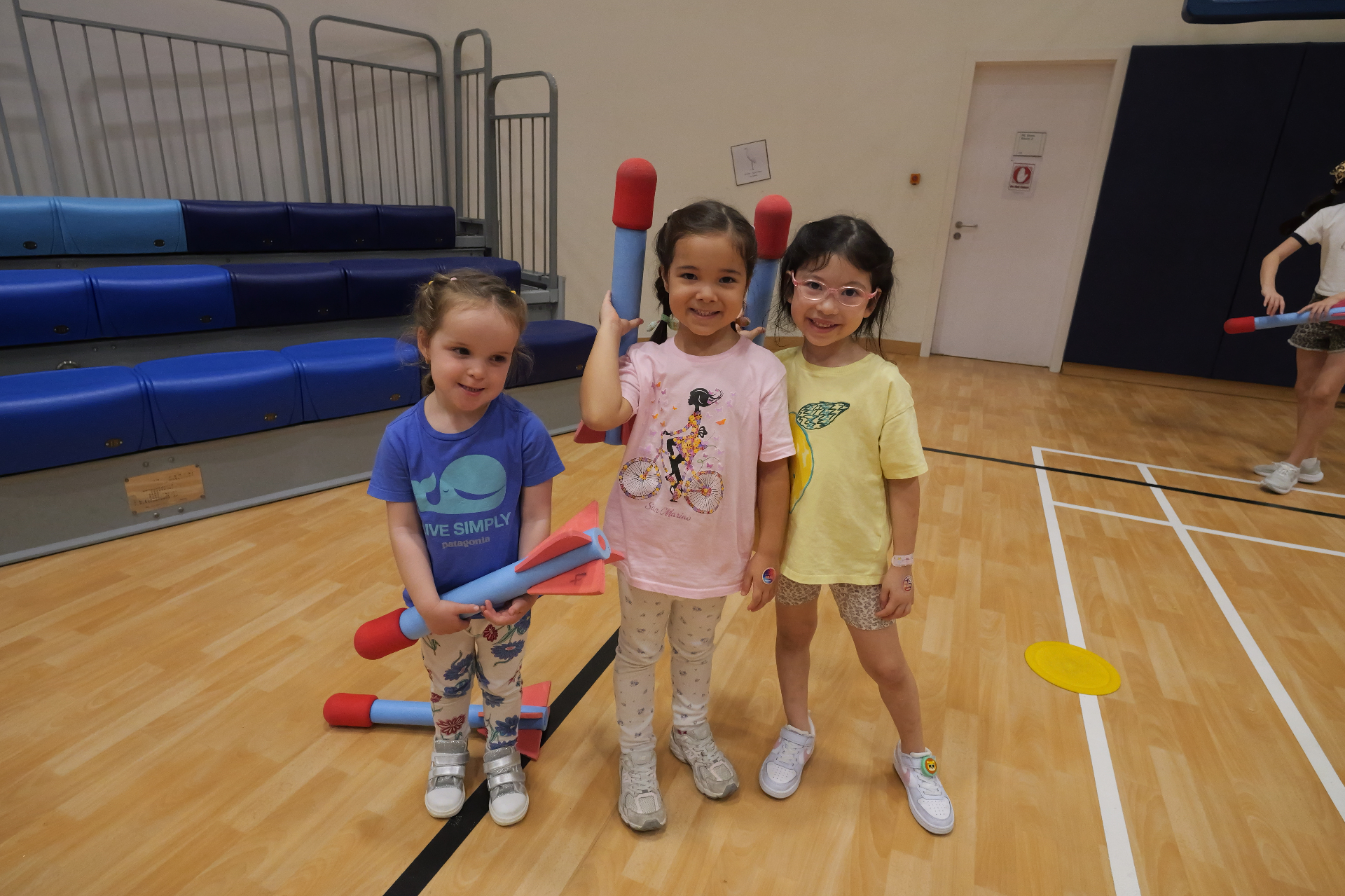 Three young children holding foam rockets at a ProActiv Hong Kong Multi-Activity Camp