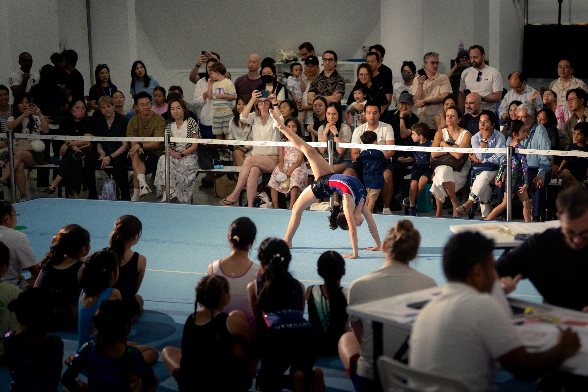 Young gymnast performing a floor routine at a ProActiv competition in Hong Kong