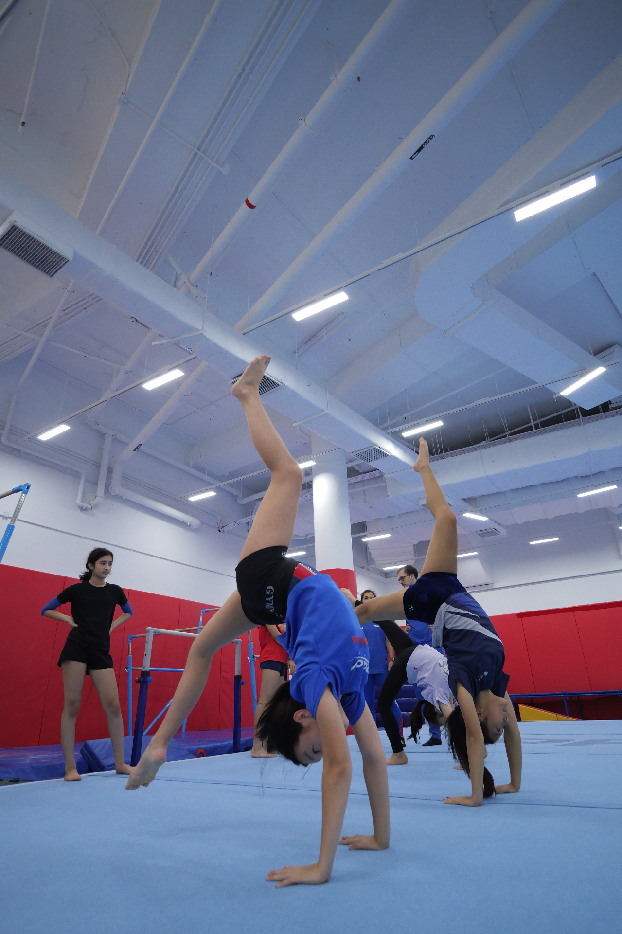 Children practising backbends and handstands on the tumbling mat at a ProActiv Hong Kong Gymnastics Camp