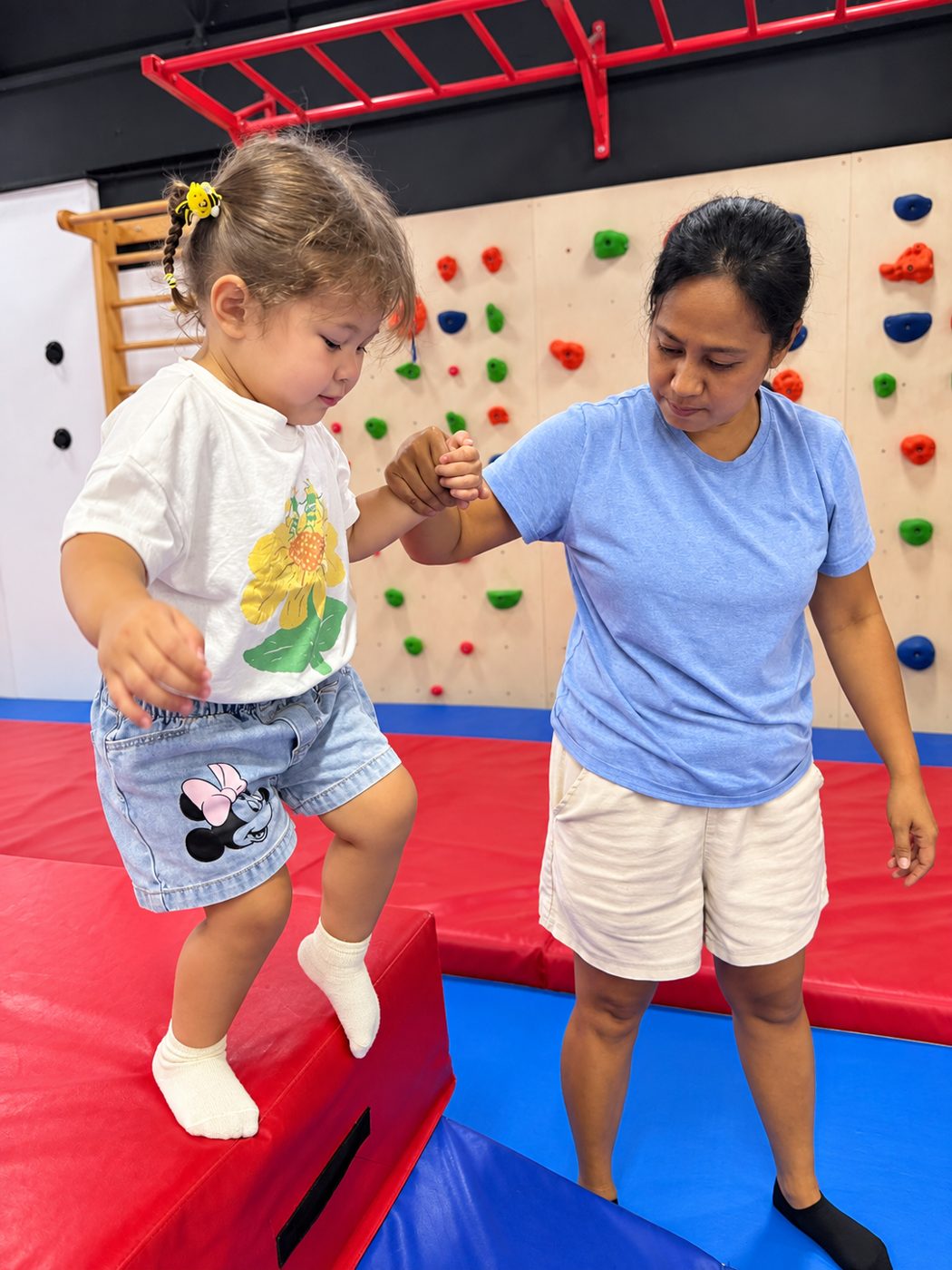 Parent supporting a toddler during a multi-sport activity at Prodigy at Katong Point